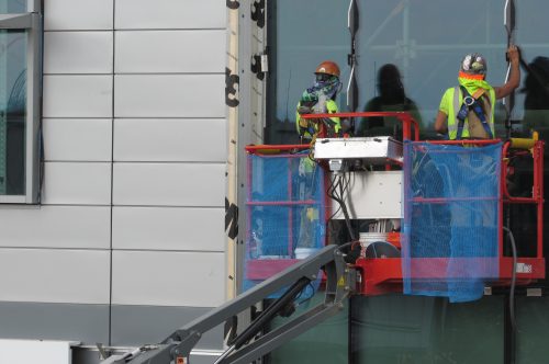 Workers put finishing touches on Denver Water's new super-sustainable administrative complex last summer. As COVID-19 cases spread,Denver and other utilities have enacted emergency operation protocols to protect workers and to keep water treatment and delivery systems operating. Credit: Jerd Smith