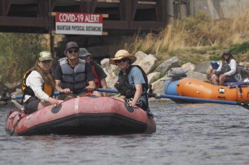 Rafters and surfers enjoy riding a wave on the Gunnison River near Gunnison, Colorado on May 17,2020. The Gunnison is flowing at about 80% of it's normal volume for this time of year. Overall, Colorado's snowpack is melting faster than usual. Along with lower river flows the presence of COVID-19 is creating challenges for commercial river running companies as well as private boaters. (Dean Krakel/Special to Fresh Water News)